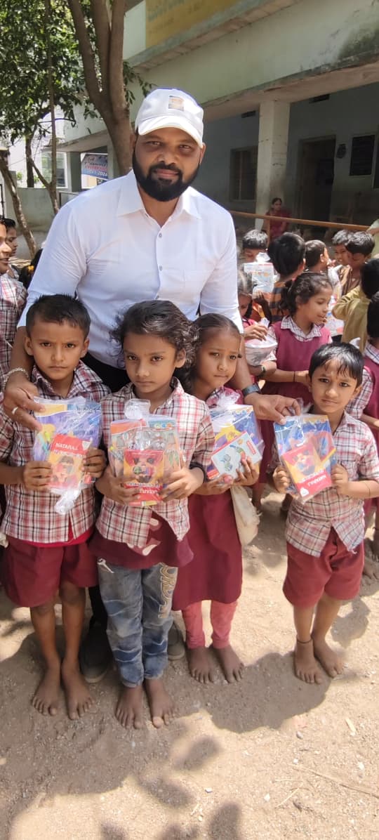 A group of primary school children proudly holding the stationery kits they received