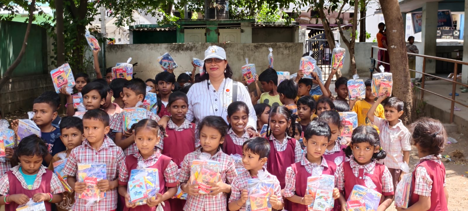 Primary government school children in Hyderabad holding stationery kits and food packs received from Smile With Shine Welfare Society as part of the 1st Anniversary Celebration on 16 July 2026